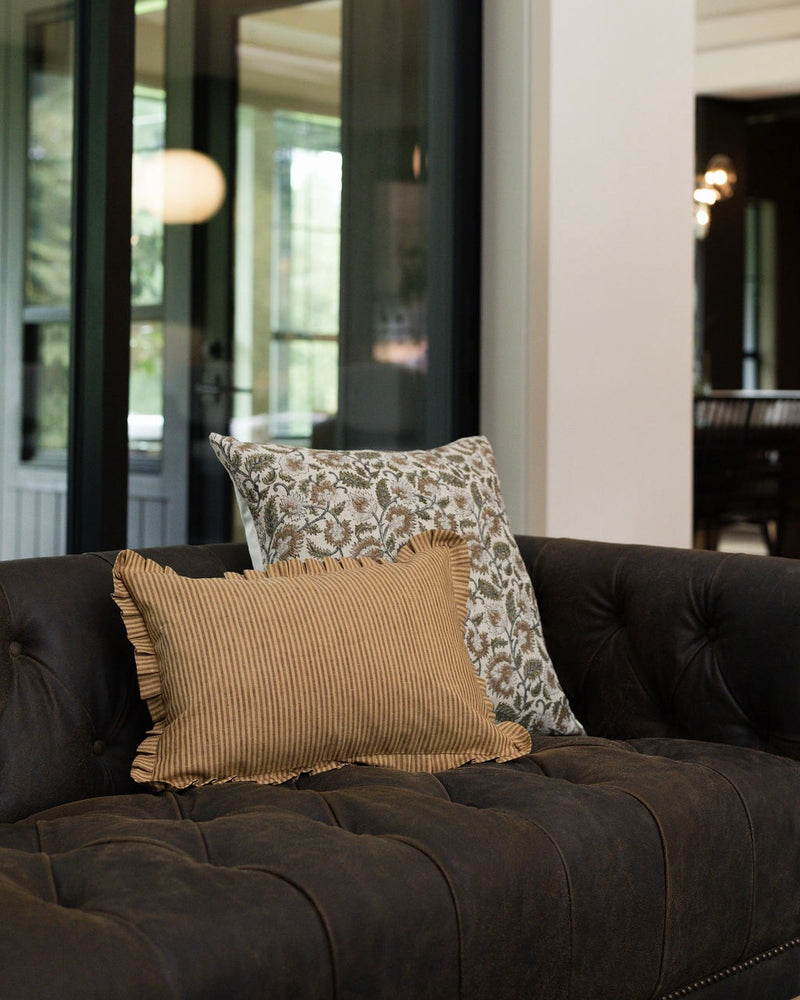 Brown sofa with patterned cushions in a living room setting