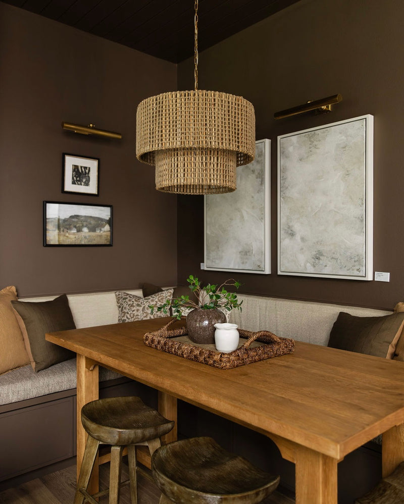 Dining room with wooden table, chairs, and a wicker pendant light.