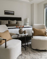 Modern bedroom with white furniture, gold accents, and a neutral color scheme.