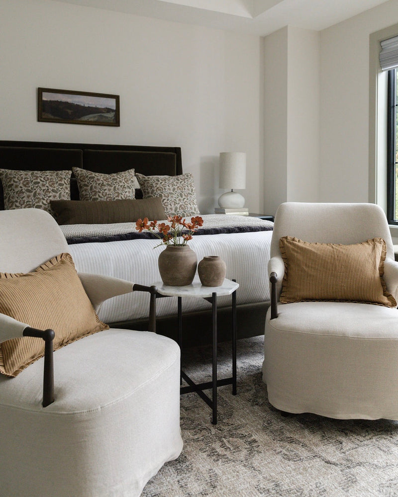 Modern bedroom with white furniture, gold accents, and a neutral color scheme.