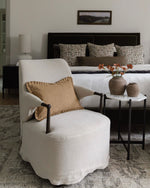 Living room with a white armchair, coffee table, and decorative pillows.