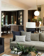 Living room with a gray sofa, decorative pillows, and a lamp.
