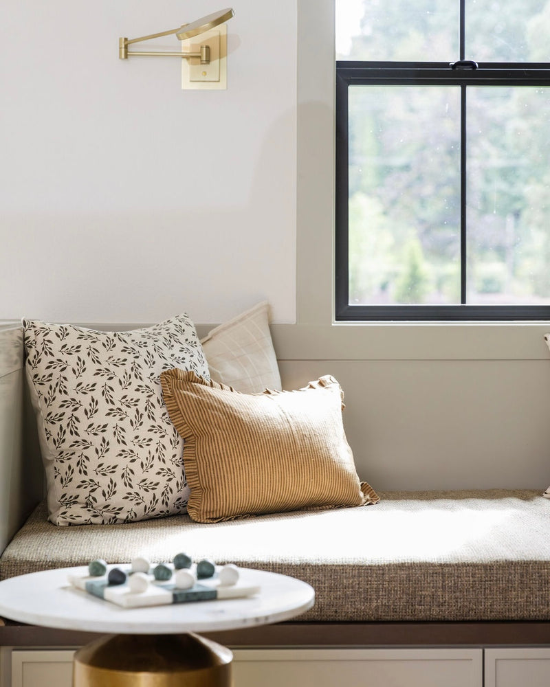 Cozy nook with pillows and a small table by a window