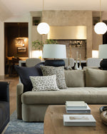 Modern living room with a beige sofa, decorative pillows, and a coffee table.