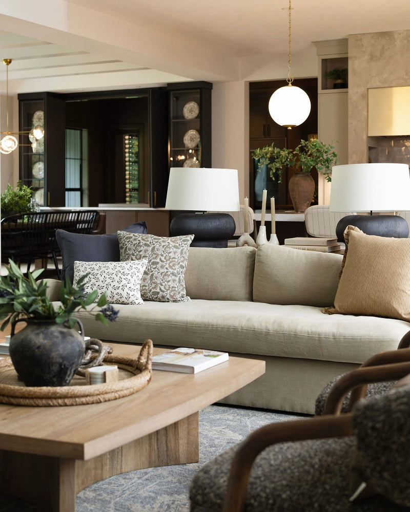 Modern living room with a beige sofa, wooden coffee table, and decorative pillows.