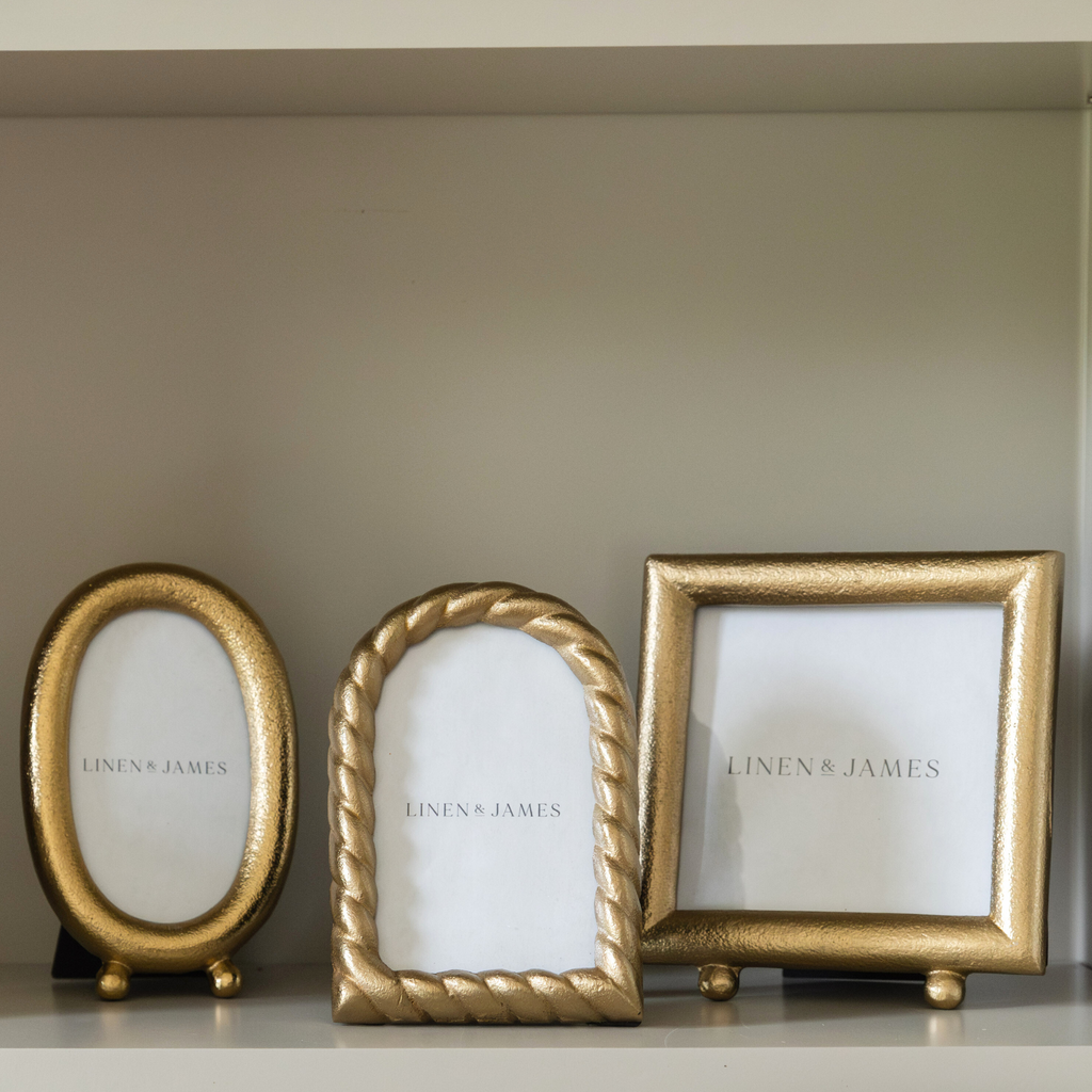 Three gold photo frames with 'Linen & James' branding on a neutral background